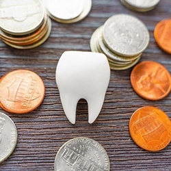 a tooth on a table surrounded by coins