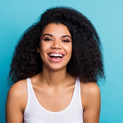 woman smiling against turquoise background 