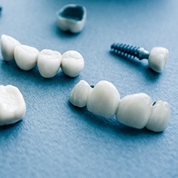 several types of dental implants in Lisle on blue background