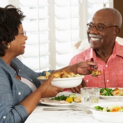 Man and woman enjoying healthy dinner in front of a white window