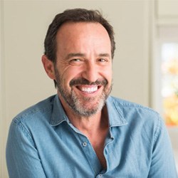 a man smiling after receiving his dental implants