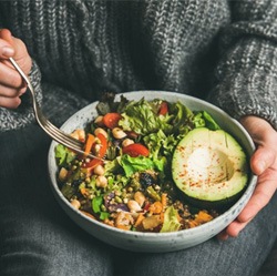 a person eating a healthy meal with veggies 