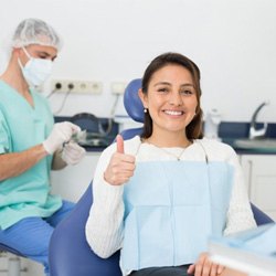 a dental patient smiling and giving a thumbs-up
