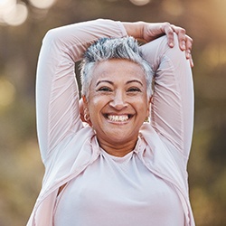 Senior woman standing outside and smiling with dentures in Lisle, IL