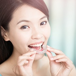 Woman placing invisalign tray