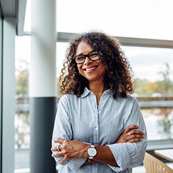 Woman in office smiling with arms folded