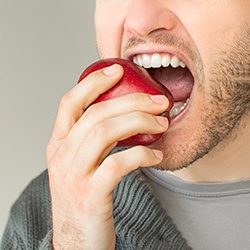 Man taking a bite out of an apple