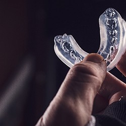 Close-up of right hand holding a mouthguard
