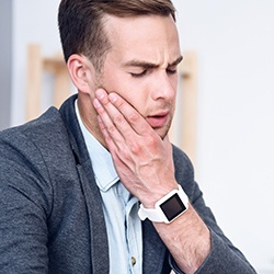 Man holding jaw in pain