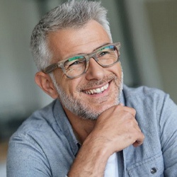 gray-haired man smiling with implant-retained dentures in Lisle