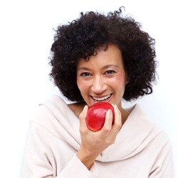 woman biting into a red apple