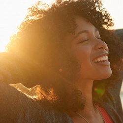 woman closing her eyes and smiling in the sunset 