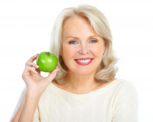 woman smiling preparing to eat apple