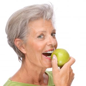 woman holding an apple smiling