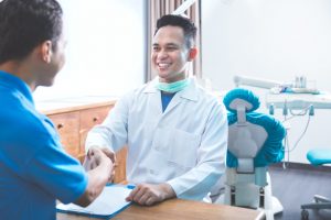 Dentist shaking hands with patient
