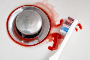 blood mixed with toothpaste on a toothbrush