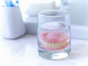 dentures soaking in glass of water