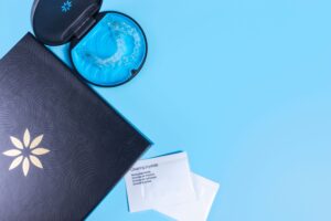 Invisalign container and trays next to 2 packets of cleaning crystals