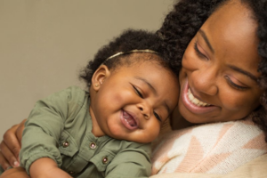 Woman holding her child and both are smiling